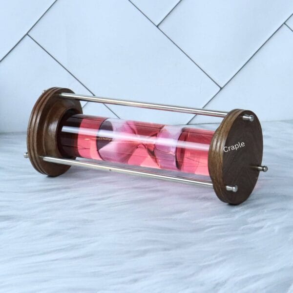 Horizontal view of the red liquid hourglass, focusing on the movement of the pink timer inside the glass tube.