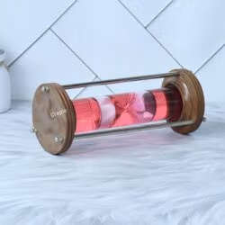 The wood and brass hourglass lying on its side, showing the detail of the polished wooden base and brass rods.