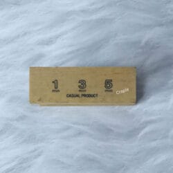 Top of the wooden sand timer showing the engraved 1, 3, and 5-minute markers.