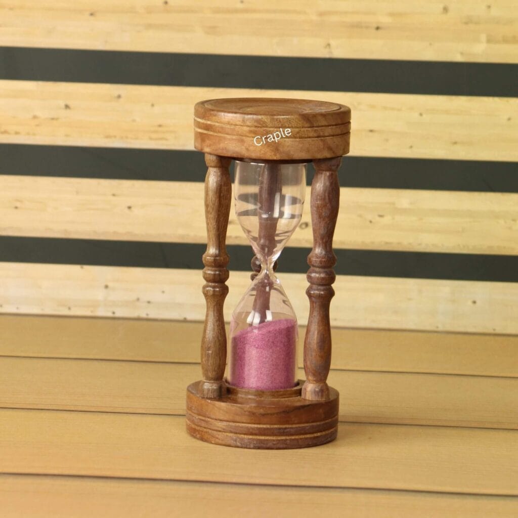 A handcrafted 5-minute hourglass with a brown wooden frame, ornate pillars, and vibrant pink sand.